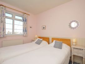 A bedroom with twin beds and a window at Cartway Cove, Port Isaac