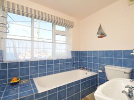 A bathroom with a bath tub and toilet at Cartway Cove, Port Isaac