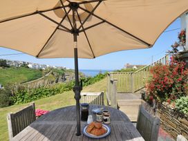 A table with cups and croissants under an umbrella at Cartway Cove, Port Isaac