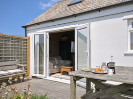 An outdoor area with a table and chairs at Cartway Cabin in Port Isaac