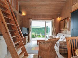 A living room with a sofa and television at Cartway Cabin Port Isaac