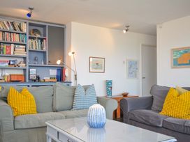 A living room with a bookshelf and seating area at Upper Gren in Trebetherick
