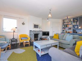A living room with a fireplace and bookshelf at Upper Gren in Trebetherick