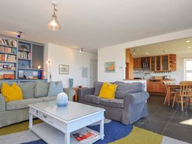 A living room with a coffee table and bookshelves at Upper Gren in Trebetherick