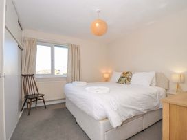 A bedroom with a bed and chair at Upper Gren in Trebetherick