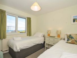 A bedroom with two beds and a window at Upper Gren in Trebetherick