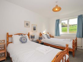 A bedroom with two beds and a window at Upper Gren in Trebetherick