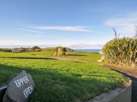 A view of the outdoor area with a sign and path at Upper Gren in Trebetherick