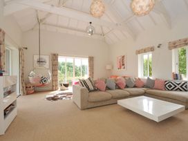 A living room with a sofa and hanging chair at The Old Granary in Rock