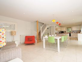 A kitchen with a dining table chairs and staircase at The Old Granary in Rock