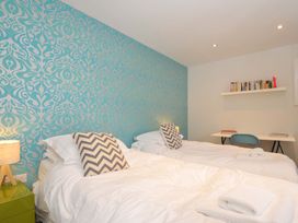 A bedroom with two beds and a shelf of books at The Old Granary in Rock