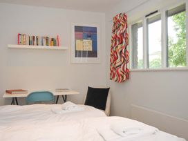 A bedroom with two beds, a desk and shelf at The Old Granary in Rock