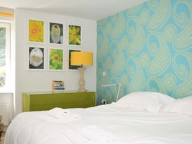 A bedroom with a bed and pictures on the wall at The Old Granary in Rock