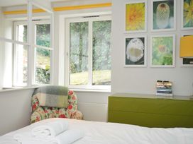 A bedroom with a bed, chair, and window at The Old Granary in Rock