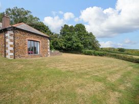 An outdoor view of a house with grass and trees at The Old Granary in Rock