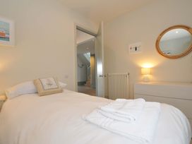 A bedroom with a bed and a lamp at The Point in Polzeath