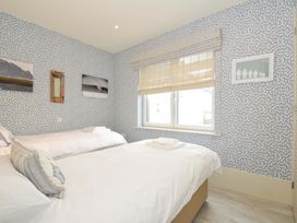 A bedroom with two beds and a window at The Point in Polzeath