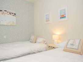 A bedroom with two beds and wall art at The Point in Polzeath