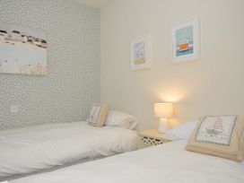 A bedroom with two beds and wall art at The Point in Polzeath
