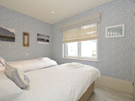 A bedroom with two beds and a window at The Point in Polzeath