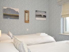 A bedroom with two beds and pictures on the wall at The Point in Polzeath