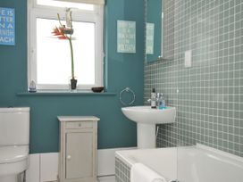 A bathroom with a toilet, basin, and bathtub at The Point in Polzeath