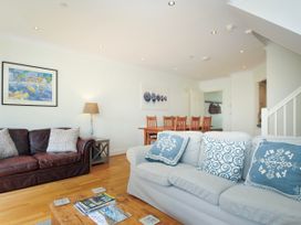 A living room with two sofas a wooden coffee table and a dining table with chairs at Lowenna Manor 3 Rock