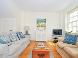 A living room with two sofas a wooden coffee table a white cabinet and a television at Lowenna Manor 3 in Rock