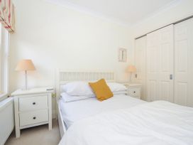 A bedroom with a white bed, bedside tables with lamps, and built-in wardrobes at Lowenna Manor 3 Rock