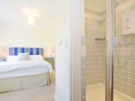 A bedroom with a bed and lamps next to an open shower with tiled walls at Lowenna Manor 3 in Rock