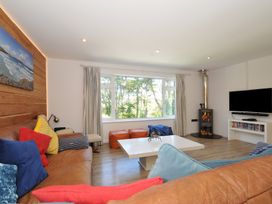 A living room with a sofa and a television at Beaches in Polzeath