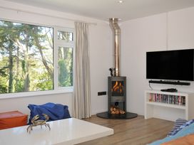 A living room with a fireplace and television at Beaches in Polzeath