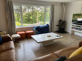 A living room with a coffee table and wood stove at Beaches in Polzeath