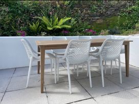 An outdoor dining table with chairs at Beaches, Polzeath