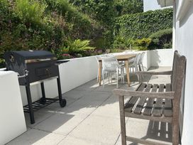 An outdoor dining area with a grill and table at Beaches in Polzeath