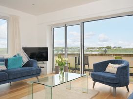 A living room with a sofa and coffee table overlooking a view at Stepper Point in Polzeath