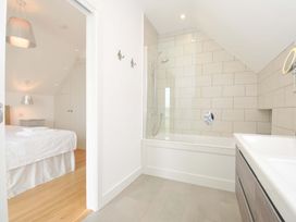 A bathroom with a shower and bathtub at Stepper Point in Polzeath