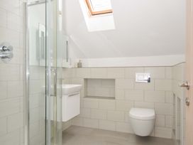 A bathroom with a shower, toilet, and sink at Stepper Point in Polzeath