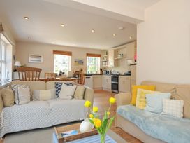 A living room with a sofa and dining area at Sandy Lodge Rock