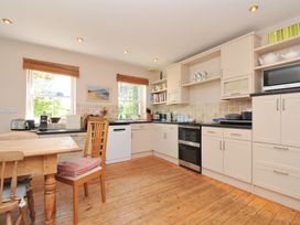 A kitchen with wooden floor and appliances at Sandy Lodge Rock