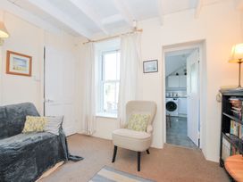 A living room with a sofa and armchair at Coppingers Cottage in Polzeath