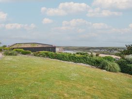 A garden with grass and hedge overlooking the sea at Hillview in Polzeath