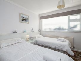 A bedroom with two single beds and a window at Hillview in Polzeath