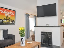 A living room with a TV and a fireplace at Orchard Cottage in Polzeath
