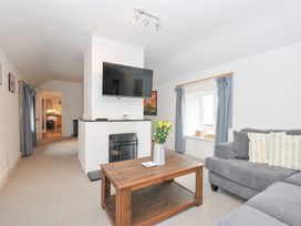 A living room with a sofa and coffee table at Orchard Cottage in Polzeath