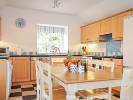A kitchen with a table and chairs at Orchard Cottage in Polzeath