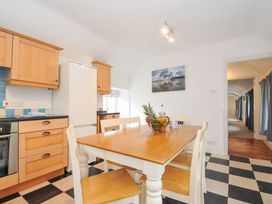 A kitchen with a dining table and chairs at Orchard Cottage in Polzeath