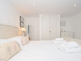 A bedroom with a bed and wardrobe at Orchard Cottage in Polzeath