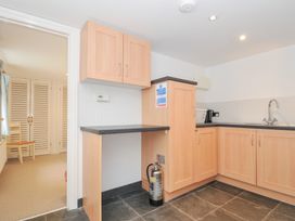 A kitchen with cabinets and a sink at Orchard Cottage in Polzeath