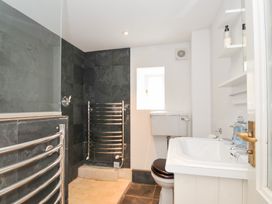 A bathroom with a shower, toilet, and sink at Orchard Cottage Polzeath